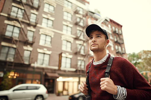 Young man walking in the city neighbourhood.