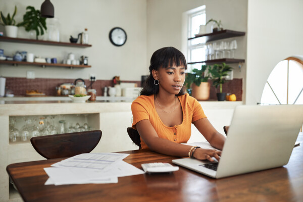 A woman working at her laptop computer in her apartment.