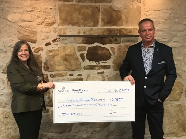 Picture of BJ Santavy, Vice President of Skyline Living and Jeff Gilpin, President of River Rock Laundry, donate funds raised during the Wash'n'Dry for the Cure campaign. The funds raised were donated to the Canadian Cancer Society.