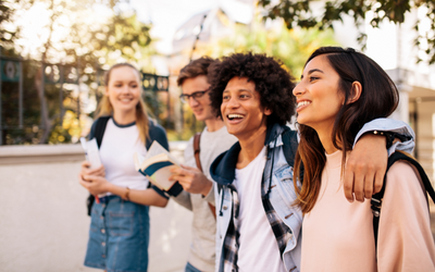 Un groupe de quatre jeunes étudiants adultes marchant tranquillement dans une rue