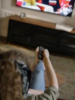 Une personne qui cherche quelque chose à regarder à la télévision.